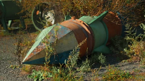 Obsolete, abandoned, and rusty combat missiles and shells stand amidst the .. Stock-Footage 345626849