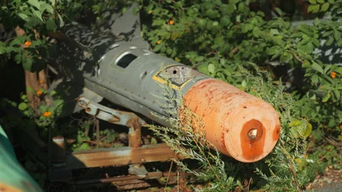 Obsolete, abandoned, and rusty combat missiles and shells stand amidst the .. Stock Footage 345626893