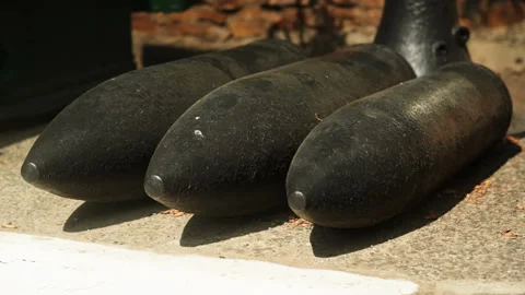 Obsolete, abandoned, and rusty combat missiles and shells stand amidst the .. Stock-Footage 346328698