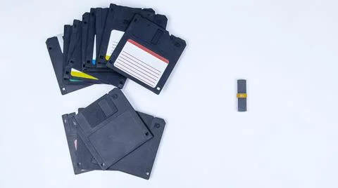 Obsolete computer floppy disks with a flash drive on a white background, Foto stock