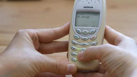 Obsolete method of writing short message on an old Nokia 3410 mobile phone Stock Footage