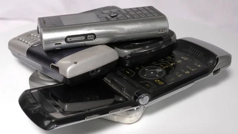 Obsolete mobile phones in stack moving on white Video stock 111887868