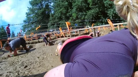 Obstacle racers crawl through mud, head to camera Video stock 170506417