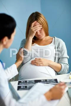 Obstetrician supporting sad pregnant female Stock Photos