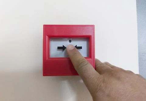Occupant pressing the emergency push button for fire alarms Stock Photos