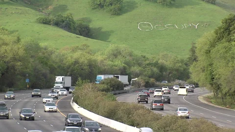 "Occupy" on hillside over freeway Stockbeeldmateriaal 203593887
