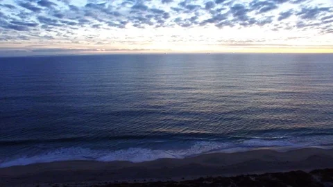 Ocean, beach and cloudy sky at sunset aerial tracking footage Stock Footage 108437895