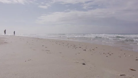 Ocean beach and people on the foreground out of focus Stock Footage 229696069