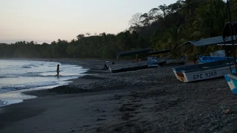 Ocean beach with boat at dusk time kid running to the beach from ocean Stock Footage 107780775