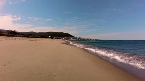Ocean beach with calm waves. Summer vacation background. Village on the seacoast Stock-Footage 156033986