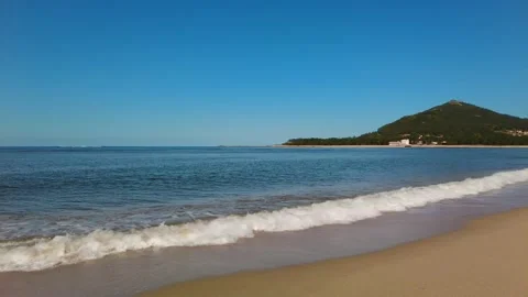 Ocean beach with the green mountain on the background. Calm sea waves. Vacation Stock-Footage 153224718