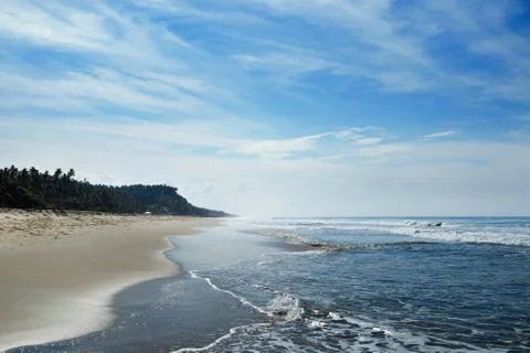 The ocean beach is in the horizon with small waves and haze. Stock Photos