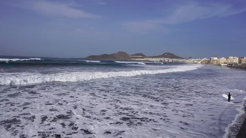 Ocean beach with huge white waves and surfer with surfboard Stock Footage 127135825