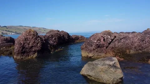 Ocean beach, slow cinematic movement between rocks and ocean 2.7k Video stock 209195063