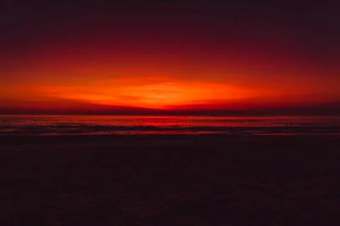 Ocean beach with waves and reflection at bright sunset or sunrise in Bali. Stock-Fotos