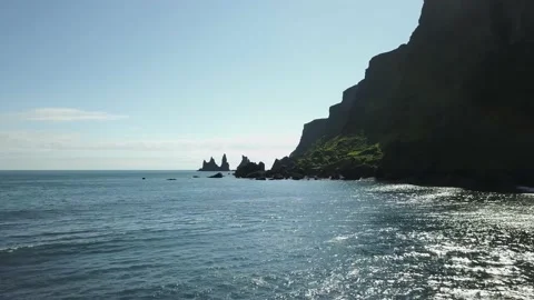 Ocean below large green rock formations aerial Stock Footage 166865189