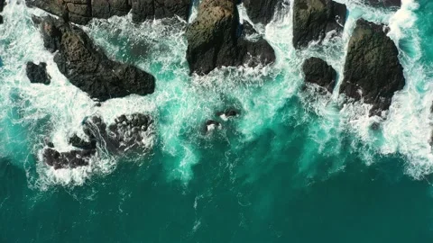 Ocean blue waves break on high cliff of a rocky mountain. Danger sea waves on a  Stock Footage 133180049