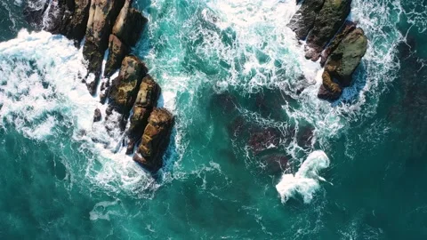 Ocean blue waves break on high cliff of a rocky mountain. Danger sea waves on a  Stock Footage 133181519