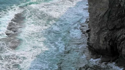 Ocean blue waves break on high cliff of a rocky mountain on a sunny autumn day Stock Footage 145998192