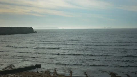 Ocean blue waves break on high cliff Stock Footage 169415540