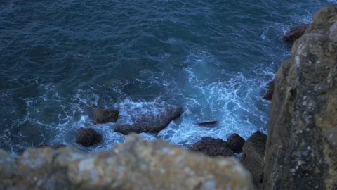 Ocean blue waves break on high cliff of a rocky mountain Stock Footage 169415598