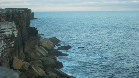 Ocean blue waves break on high cliff Stock Footage 169415675