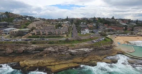 Ocean breaks on massive rocks within residential area Stock Footage 70825505