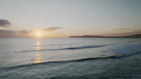 The ocean is calm and the sun is setting, creating a beautiful Stock Footage 297078158