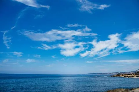 Ocean cliffs cloudscape and boat Stock Photos