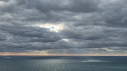 Ocean, clouds, sky, dramatic ocean view with sun rays peeking through dark Stock Footage 320467489