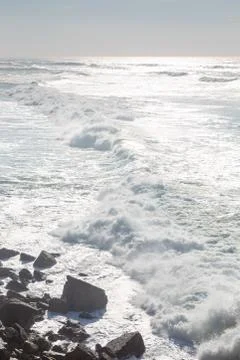 Ocean coast, moviment waves with foam. Wind power. Turquoise water. Stock Photos