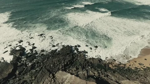 Ocean crashes against rugged cliffs with frothy white waves Stock Footage 341823119