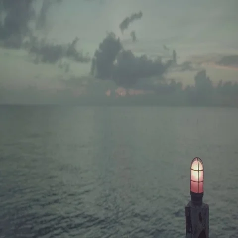 Ocean at Dusk With Red Light in Foreground Stock Footage 69699406