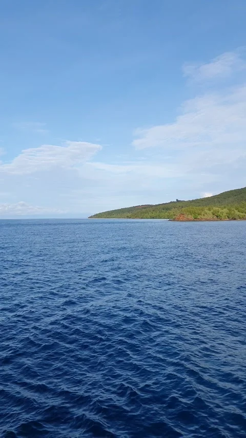 Ocean with green mountain background Stock Footage 293992291