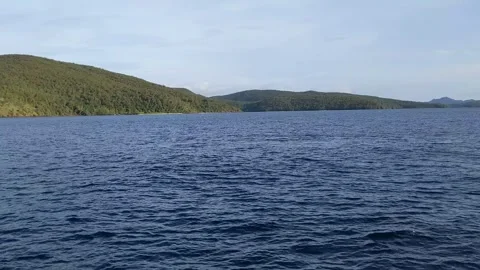 Ocean with green mountain background Stock Footage 294016346