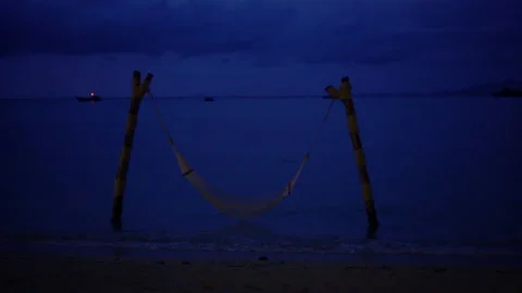 Ocean hammock in sea level tide relax evening on tropical island navy sky Stock Footage 155976041