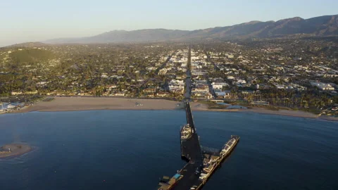 Ocean harbor pier looking toward town beach city and mountains in background Stock Footage 150074313