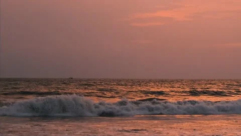 Ocean horizon is at sunset. Mesmerizing view of raging orange foaming waves  Stockbeeldmateriaal 188424386