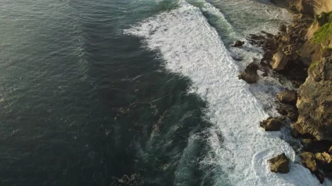 Ocean landscape of turquoise waves breaking on stone cliffs. Top aerial view Stock Footage 217496192