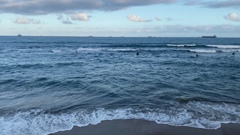 Ocean laps on beach ships in background Stock Footage 255651793