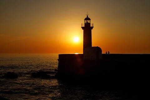 Ocean lighthouse at the sunset. Stock Photos