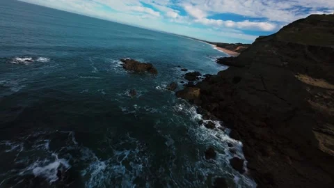 Ocean meets jagged cliffs under dynamic sky Stock Footage 340905316