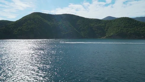 Ocean with mountain coastline and blue sky Stock Footage