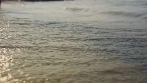 Ocean or sea frothy waves lapping onto wet sand on a beach on sunny day Stock-Footage 332166025