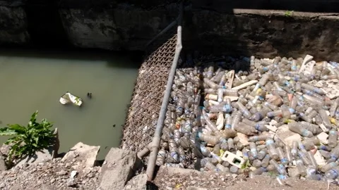 Ocean plastic barrier stopping plastic water bottles from washing into ocean in Stock Footage 337960675
