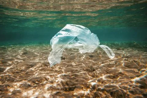 Ocean pollution concept, plastic bag floating in the water Stock Photos