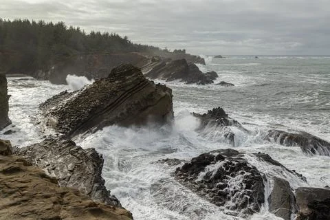 The ocean is rough and the waves are crashing against the rocks Stock Photos