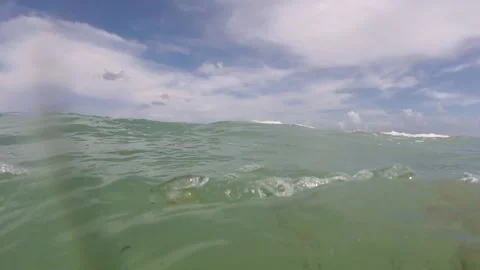 In the ocean in rough waters going in and out of the water. Stock Footage 203803062