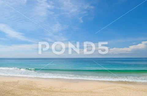 Ocean, sandy beach and blue sky Stock Photos