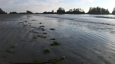 Ocean sandy beach with soft lapping waves with silhouetted islands. Stock Footage 52221587